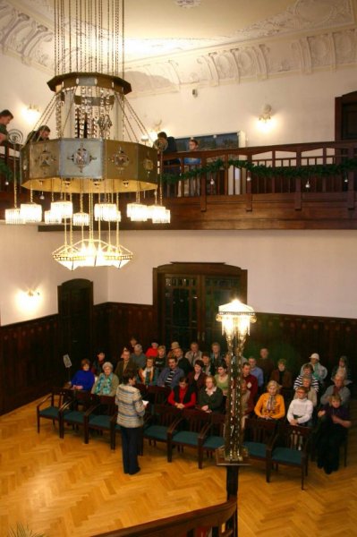 Publikum v reprezentativním sále pod historickým lustrem